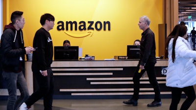 Employees walk through a lobby at Amazon's headquarters in Seattle, Nov. 13, 2018.